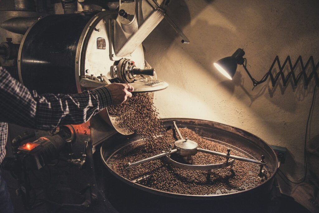 Person brewing coffee with a reusable filter beside a compost container and glass storage jar.
